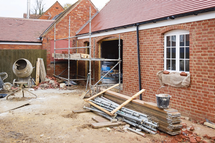Home building site with brick house extension under construction
